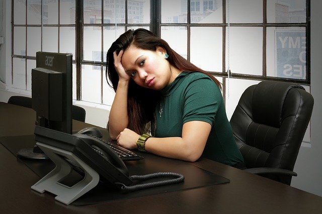žena, která sedí před počítačem a tváří se dost nešťastně